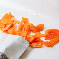 top-view-dried-apricot-pieces-inside-outside-little-paper-package-white(1)